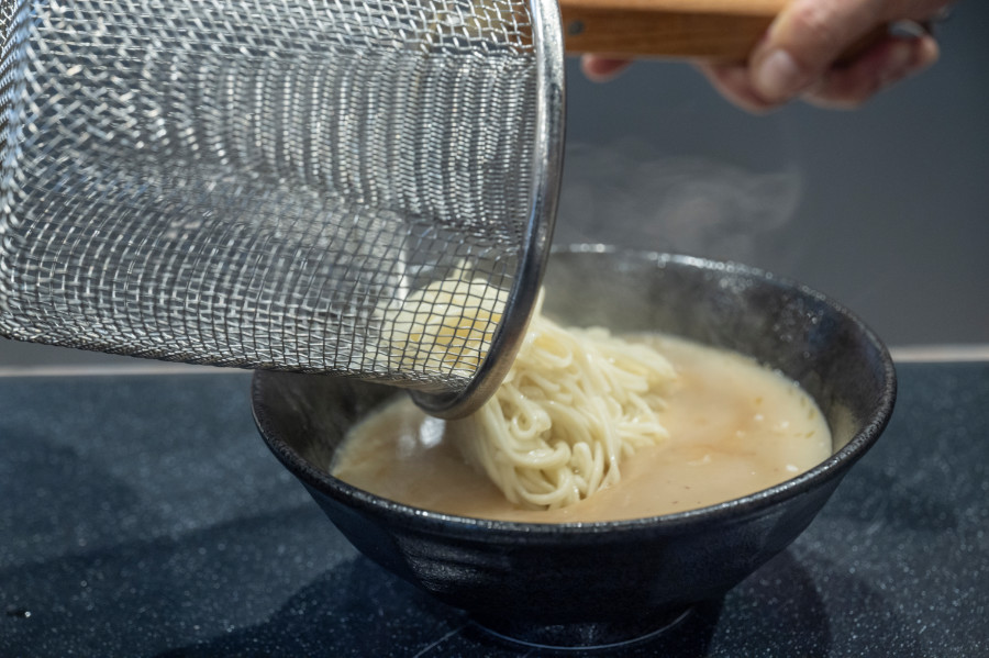 温めたスープと自家製麺を丼で合わせます